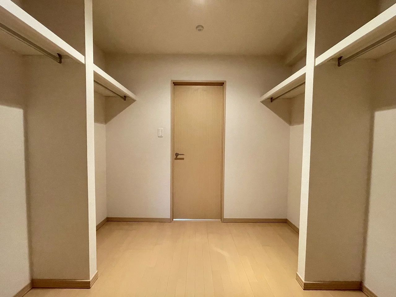 賃貸マンションのウォークインクローゼットに備え付けられた棚とハンガーパイプ